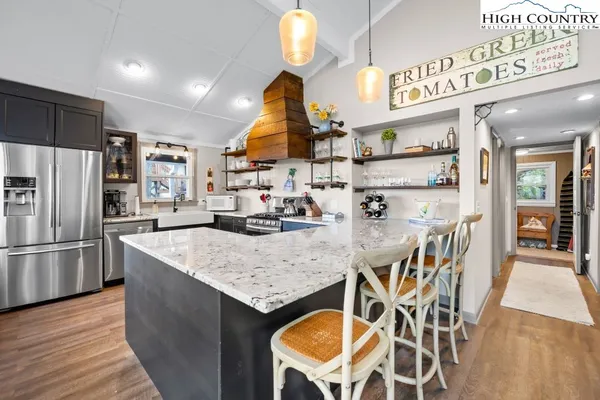 a kitchen with stainless steel appliances granite countertop a sink a stove and a refrigerator