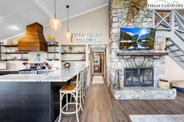 a kitchen with stainless steel appliances granite countertop a sink a stove and a wooden floors