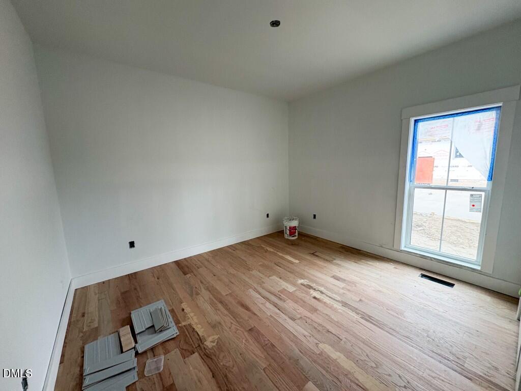 5013 Mitchell Town Road Youngsville, NC 27596 - Photo 11 of 15 an empty room with wooden floor and windows