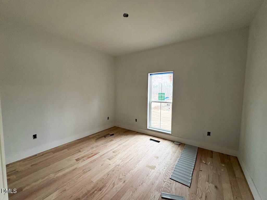 5013 Mitchell Town Road Youngsville, NC 27596 - Photo 13 of 15 a view of an empty room with wooden floor and a window