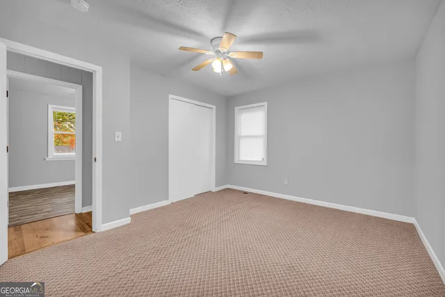 a view of an empty room with a ceiling fan