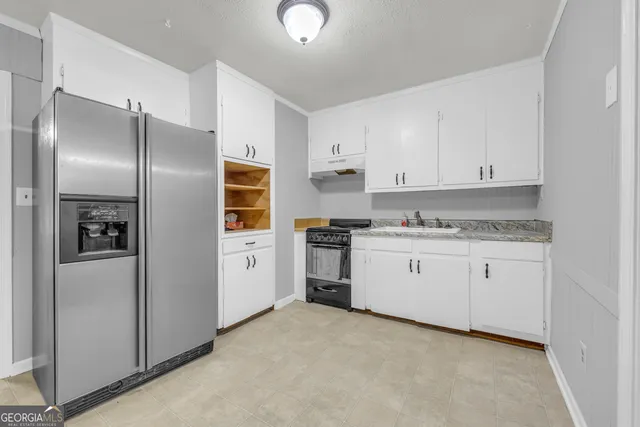 a kitchen with stainless steel appliances a refrigerator and a stove top oven