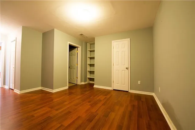 an empty room with wooden floor and closet