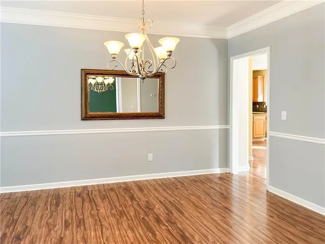 a view of a room with wooden floor and chandelier