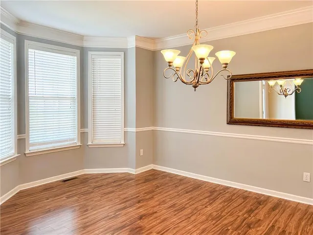 a view of a room with wooden floor and chandelier