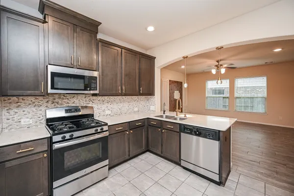 a kitchen with granite countertop stainless steel appliances a stove sink and microwave