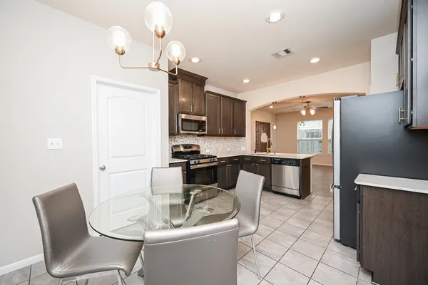 a kitchen with sink a refrigerator and chairs