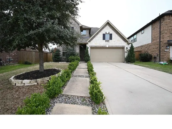 a front view of a house with a yard and trees
