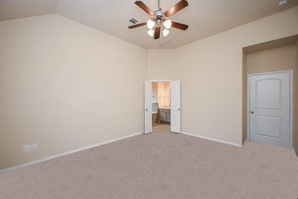 a view of an empty room and chandelier fan