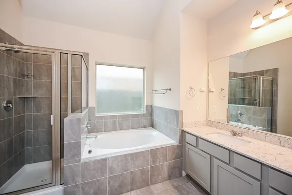 a spacious bathroom with a granite countertop tub sink a shower and a mirror