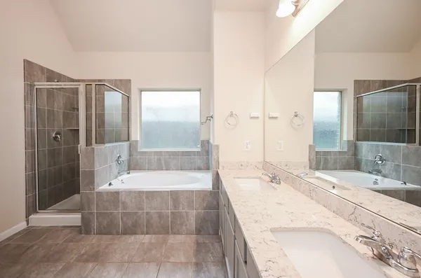 a bathroom with a tub shower and sink