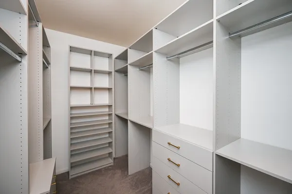 a view of walk in closet with empty racks