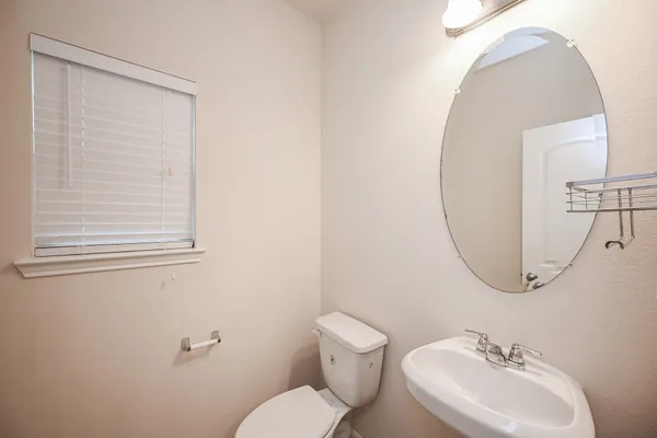 a bathroom with a sink mirror and toilet