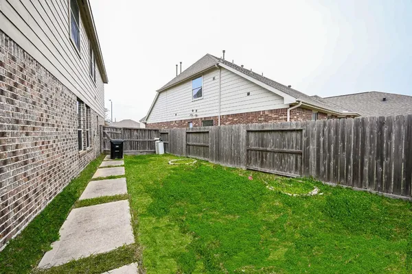 a view of a house with a yard and pathway