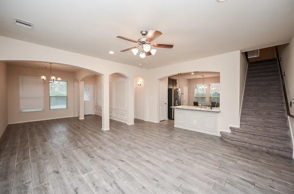a view of an empty room with window and wooden floor