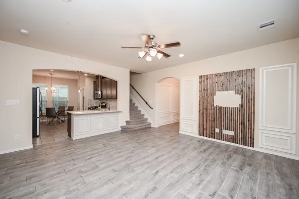 a view of a livingroom with wooden floor and a ceiling fan