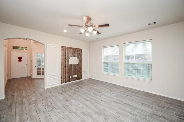 a view of an empty room with a window and wooden floor