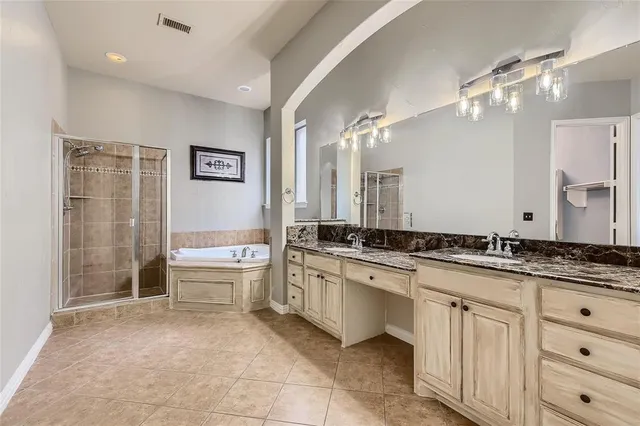 a spacious bathroom with a granite countertop tub sink and mirror