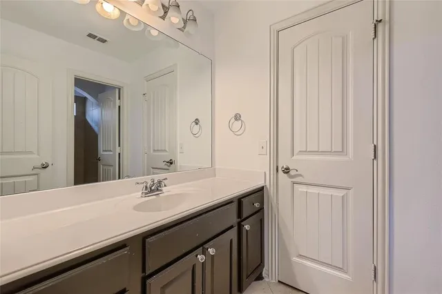 a bathroom with a sink vanity and a mirror