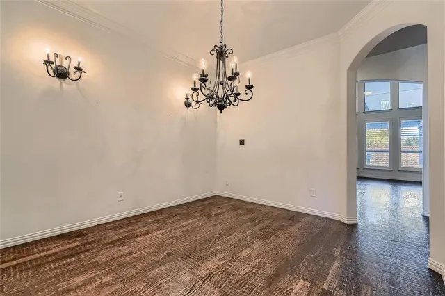 a view of a hallway with wooden floor and a chandelier