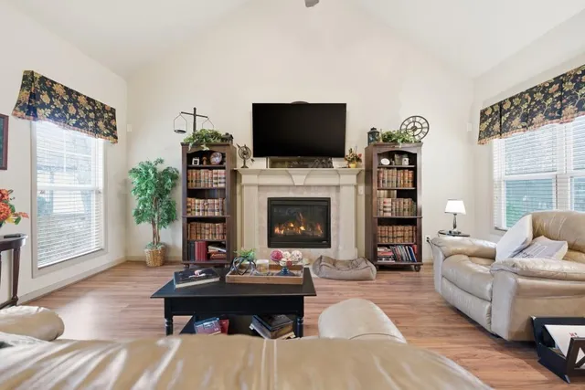 a living room with furniture a flat screen tv and a fireplace