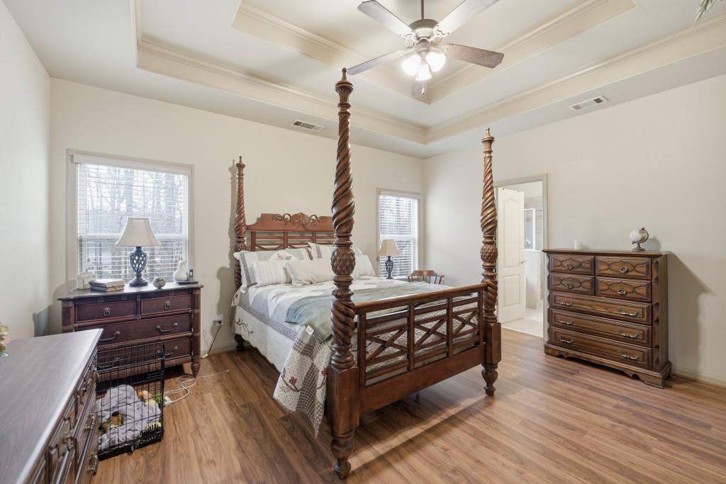 53 Bobbin Court Jefferson, GA 30549 - Photo 23 of 40 a spacious bedroom with a bed a chandelier and a dresser