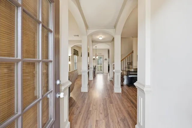 a view of a hallway with wooden floor and staircase