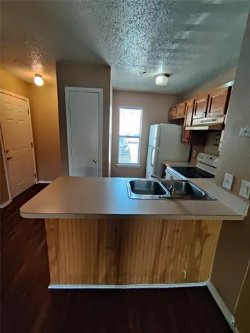 a living room with a table chairs and a refrigerator