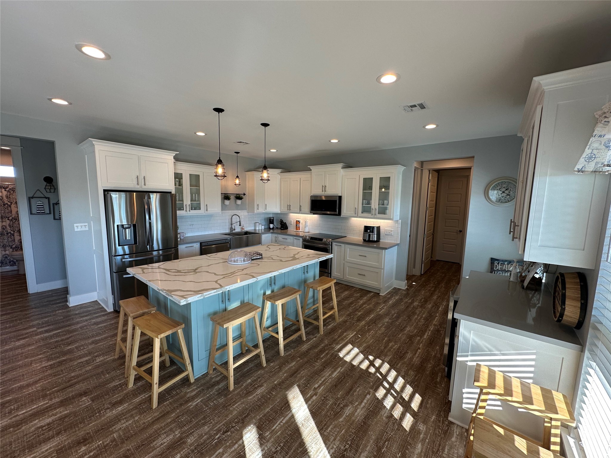 2429 Sand Castle Crystal Beach, TX 77650 - Photo 16 of 46 a kitchen with stainless steel appliances granite countertop a stove refrigerator a dining table and chairs with wooden floor