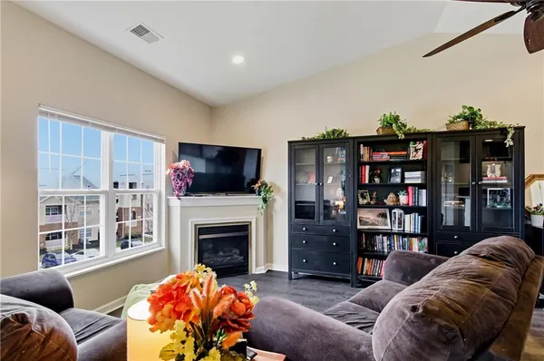 a living room with furniture a flat screen tv and a fireplace