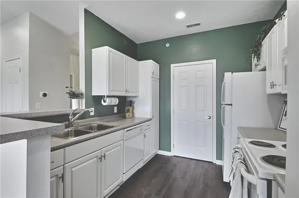 a kitchen that has a sink a stove and a wooden floors