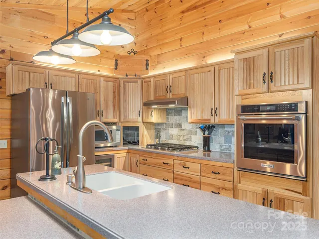 a kitchen with stainless steel appliances granite countertop a sink and cabinets