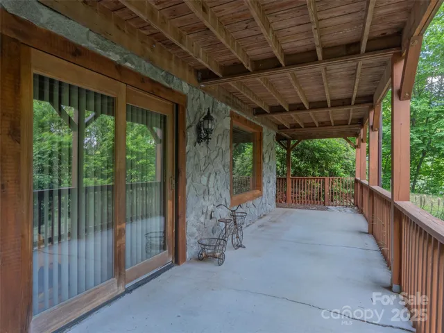 a view of a deck with wooden floor and fence next to a yard