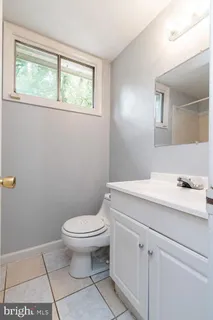 a bathroom with a sink a toilet and a window