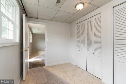 an empty room with window and bathroom