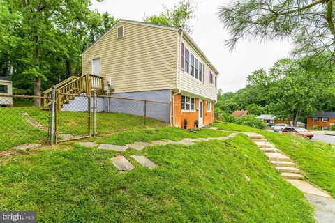 a view of a house with a yard and sitting area