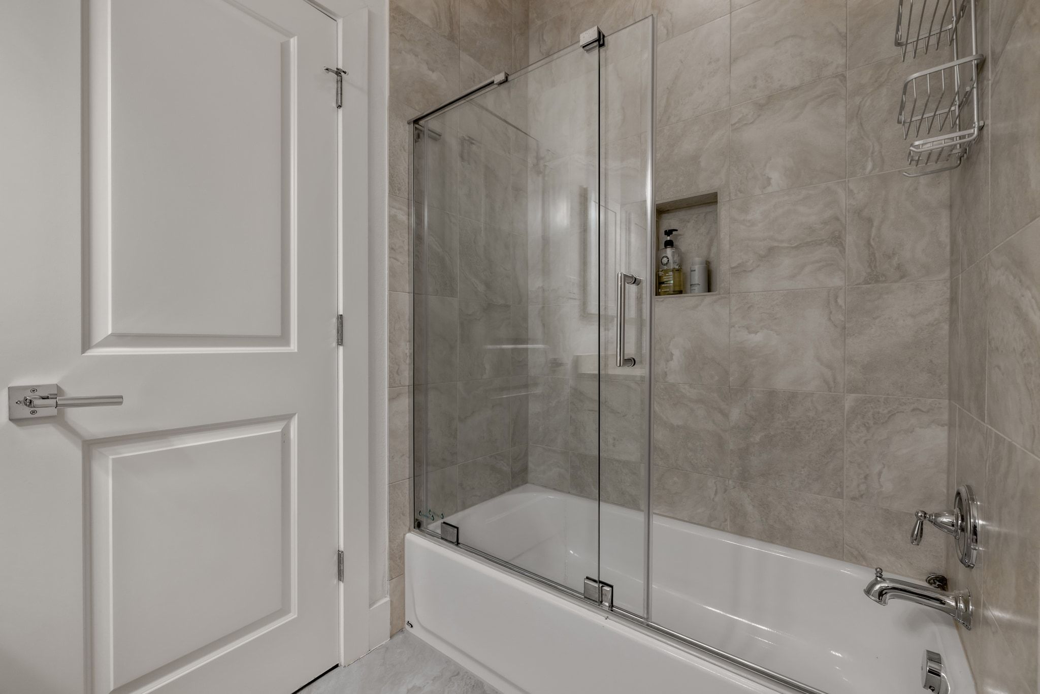 4720 Rockcliff Road, Unit 1 Austin, TX 78746 - Photo 35 of 39 A sleek, contemporary tub and shower combination features extensive tile work and a functional glass enclosure.