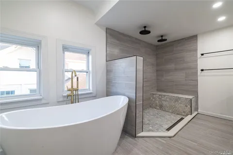 a white bath tub sitting in a bathroom next to a window