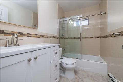 a bathroom with a shower sink vanity mirror and toilet