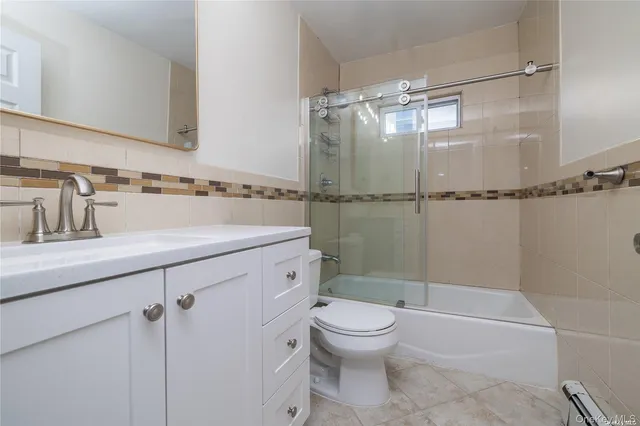 a bathroom with a shower sink vanity mirror and toilet
