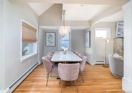 a dining hall with granite countertop wooden floor and chandelier