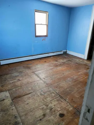 a view of a room with wooden floor and windows