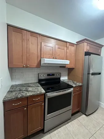 a kitchen with stainless steel appliances granite countertop a stove a refrigerator and a cabinets