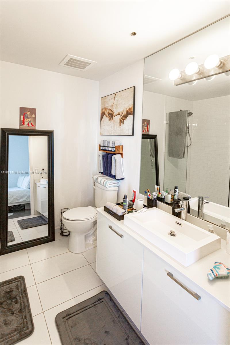 151 Southeast 1st Street, Unit 2204 Miami, FL 33131 - Photo 11 of 34 a bathroom with a double vanity sink mirror and toilet