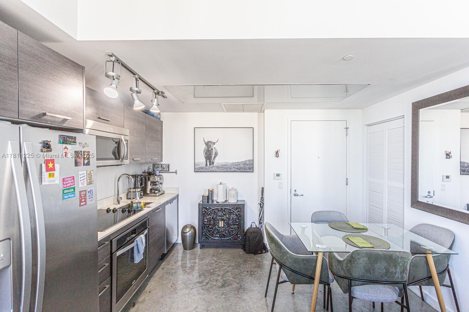 151 Southeast 1st Street, Unit 2204 Miami, FL 33131 - Photo 14 of 34 a kitchen with stainless steel appliances a refrigerator and table chair