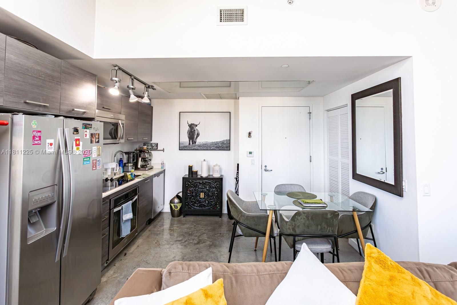 151 Southeast 1st Street, Unit 2204 Miami, FL 33131 - Photo 6 of 34 a kitchen with stainless steel appliances kitchen island granite countertop a refrigerator and stove