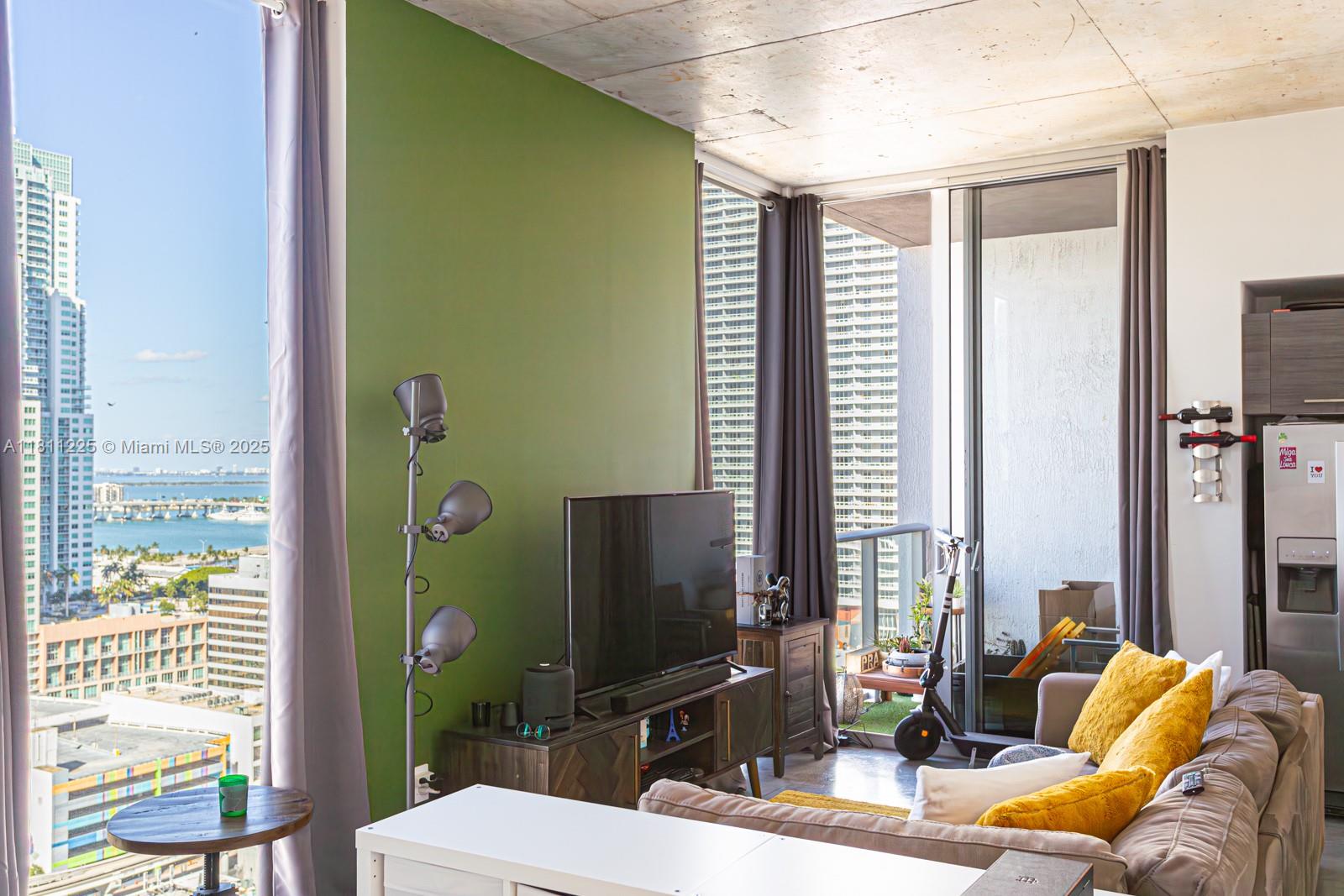 151 Southeast 1st Street, Unit 2204 Miami, FL 33131 - Photo 7 of 34 a living room with furniture and a flat screen tv