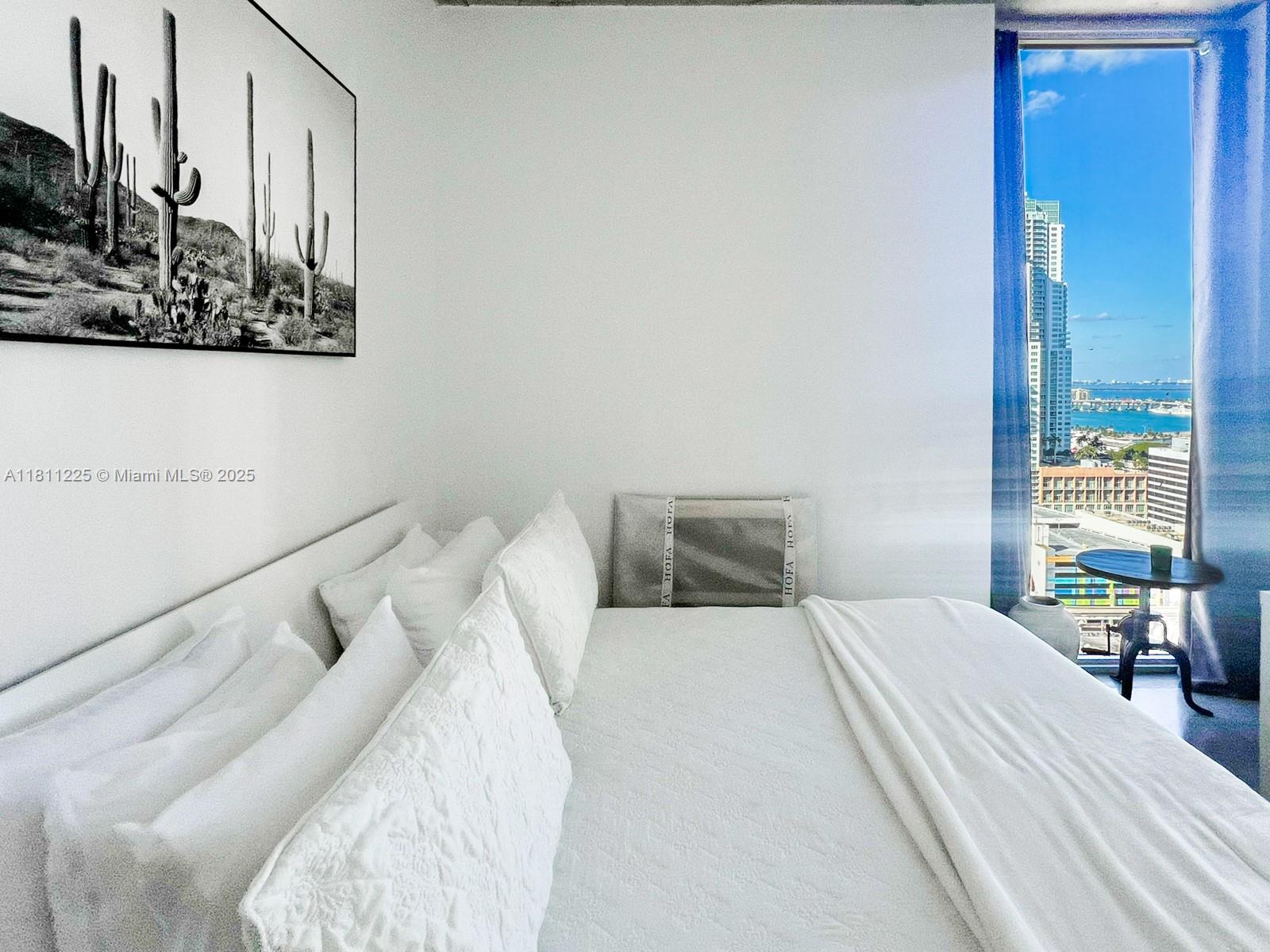 151 Southeast 1st Street, Unit 2204 Miami, FL 33131 - Photo 10 of 34 a bedroom with a bed and a night stand