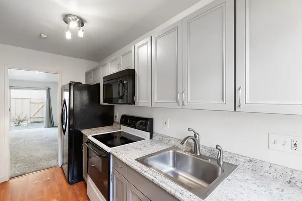 a kitchen that has a sink cabinets counter space and stainless steel appliances