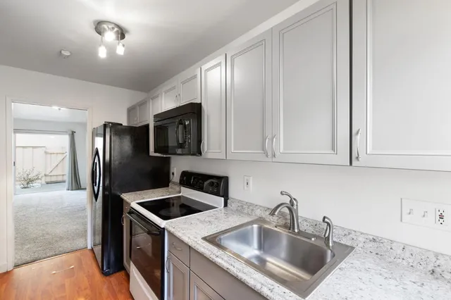 a kitchen that has a sink cabinets counter space and stainless steel appliances